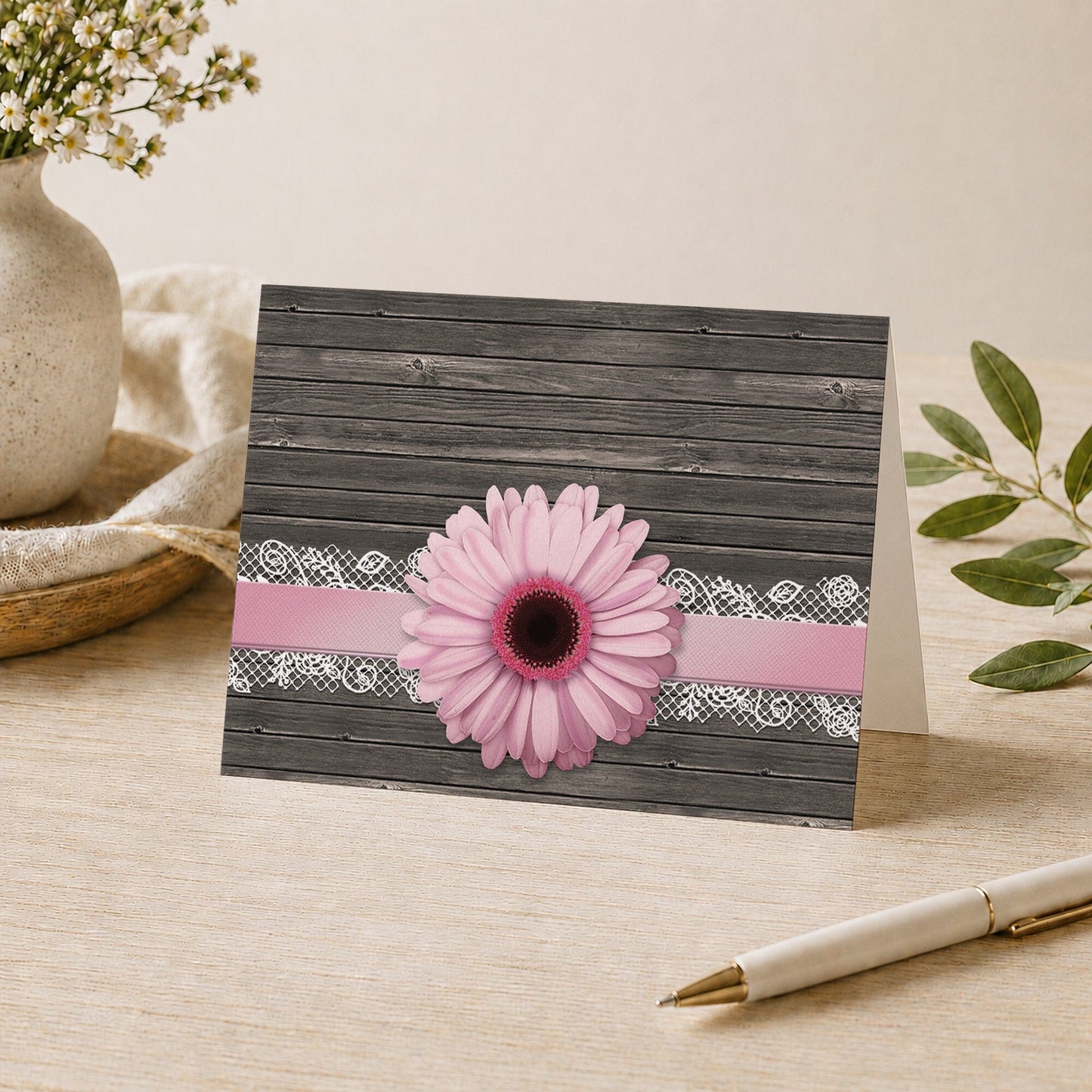 Pink Daisy Lace Rustic Wood Note Card shown on a desk with a vase, plants, and a pen.