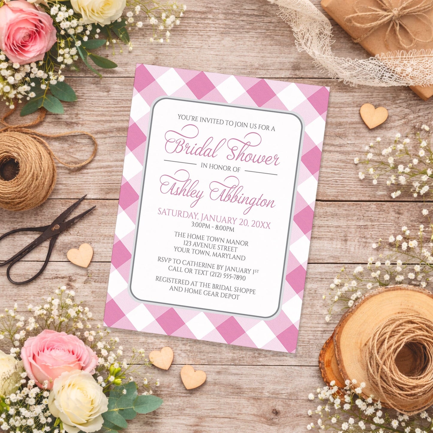 Pink Gingham Bridal Shower Invitation shown on a rustic wood surface with spring and summer flowers, small wood hearts, white lace ribbon, and twine.