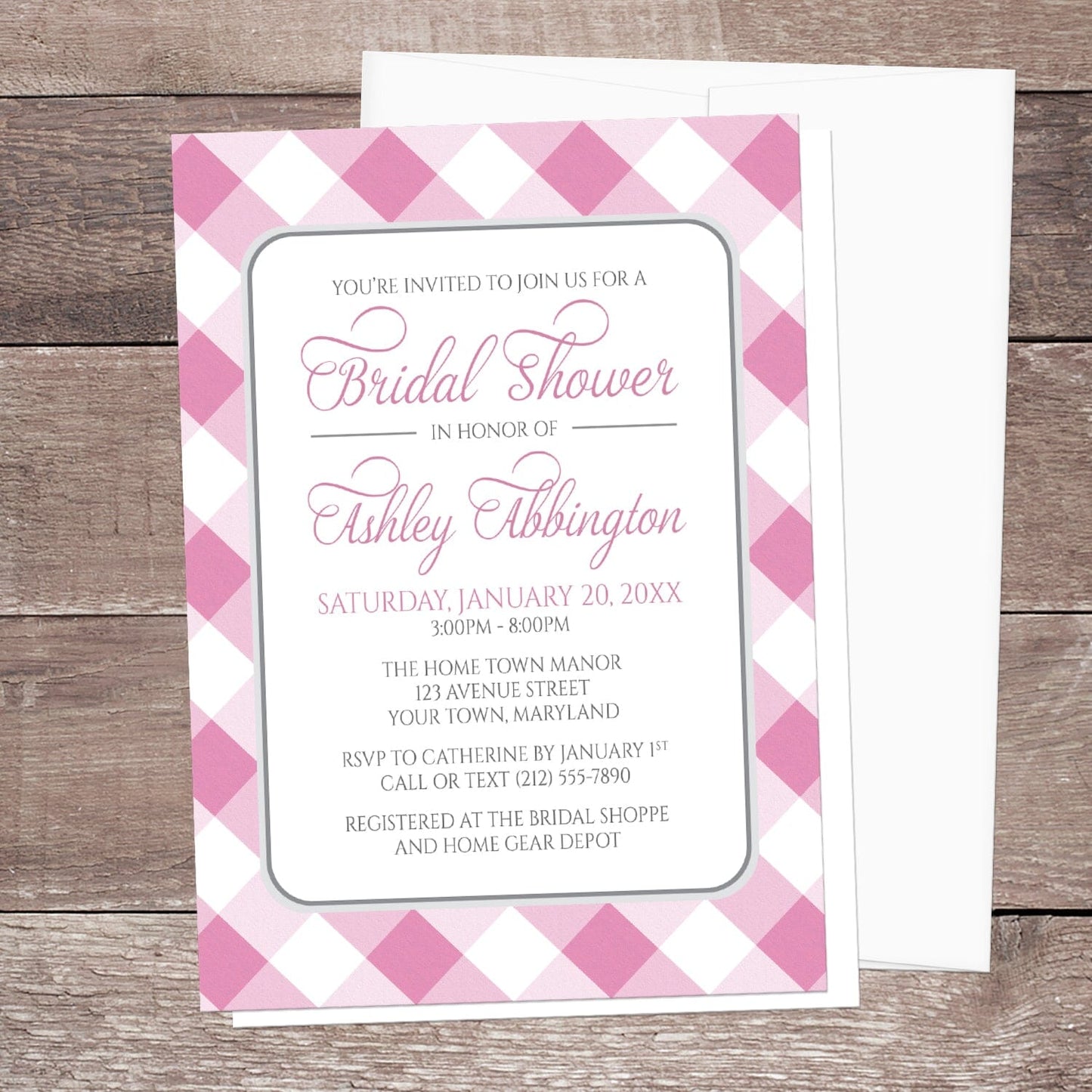 Pink Gingham Bridal Shower Invitation shown on a wooden surface with a white envelope.