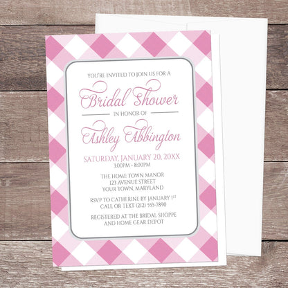 Pink Gingham Bridal Shower Invitation shown on a wooden surface with a white envelope.