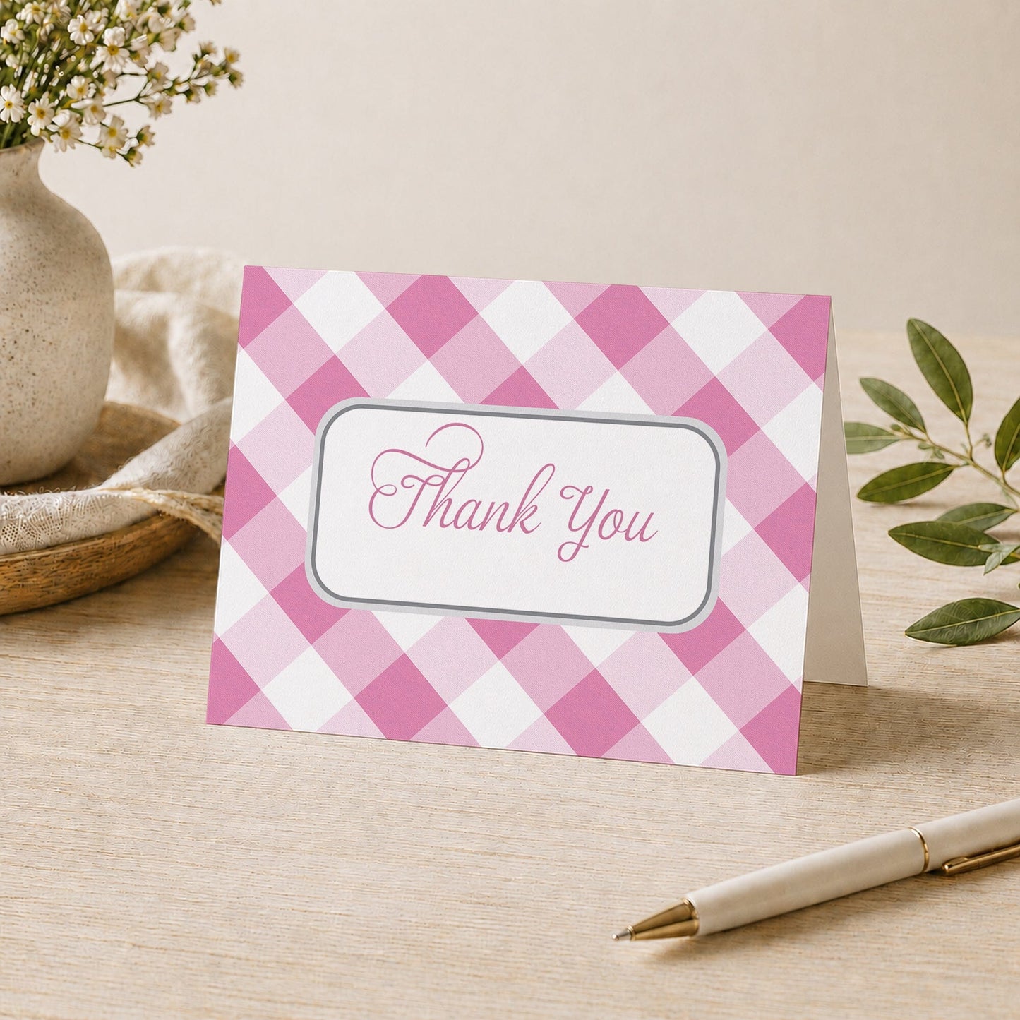 Pink Gingham Thank You Card shown on a desk with a vase, plants, and a pen.
