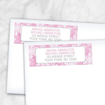 2 Pink Snowflake Winter Return Address Labels shown on white envelopes on a marble surface
