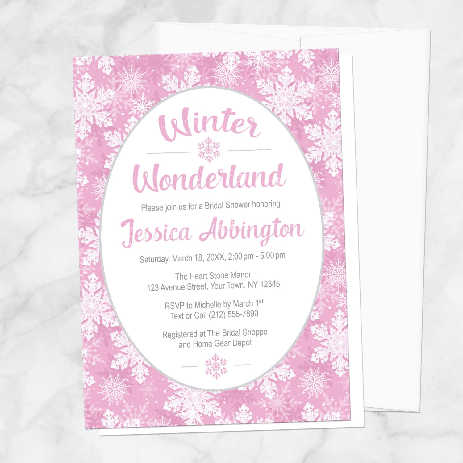Pink Snowflake Winter Wonderland Bridal Shower Invitation shown on a marble surface with a white envelope.