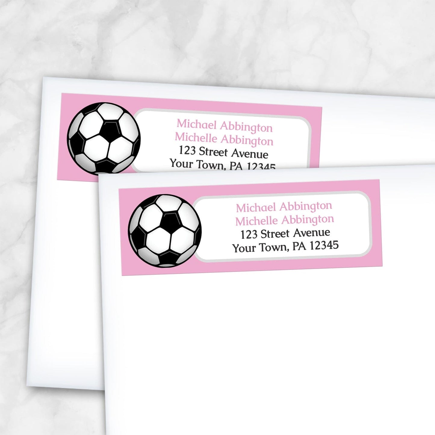2 Pink Soccer Ball Return Address Labels shown on white envelopes on a marble surface