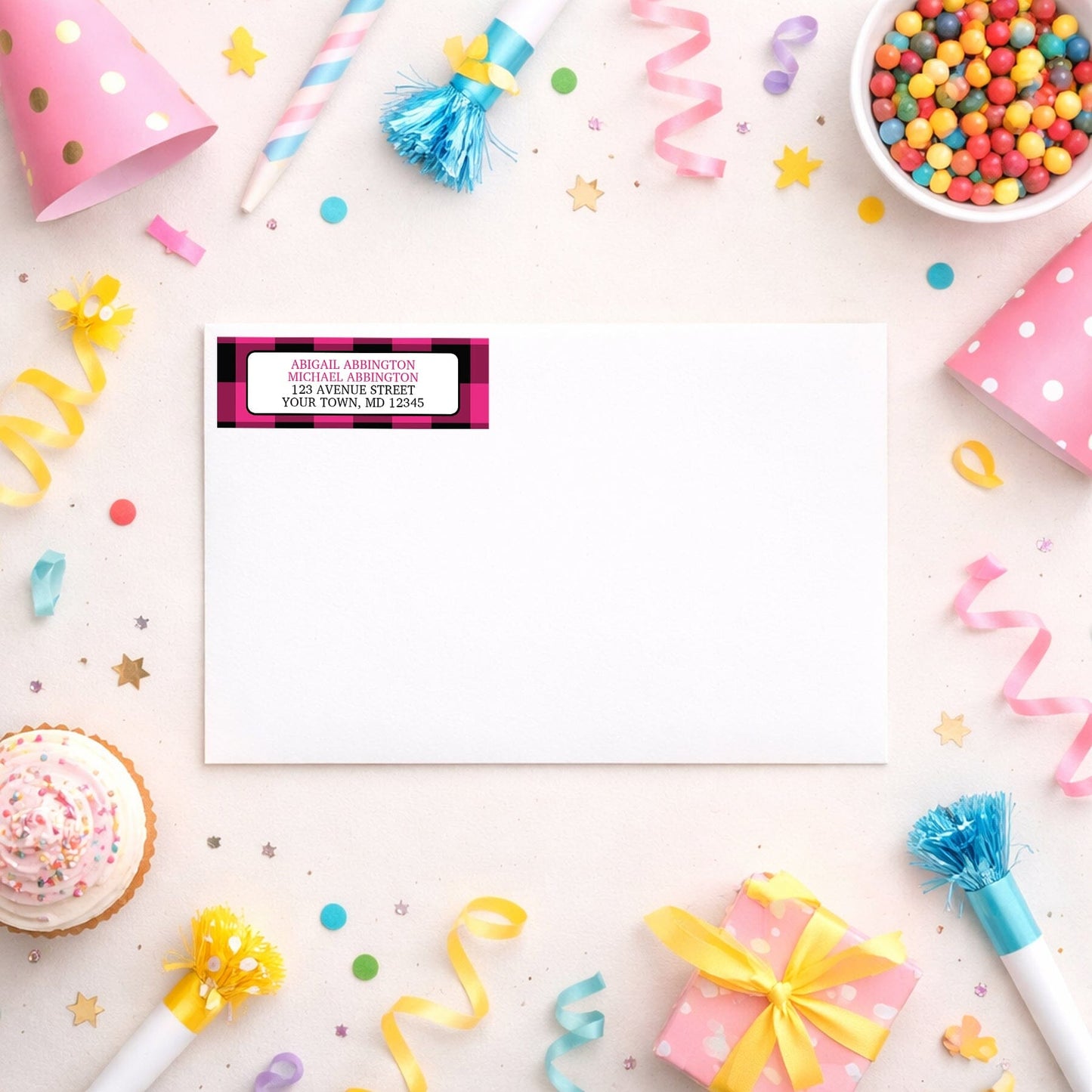 Pink and Black Buffalo Plaid Address Label shown on a white envelope with party supplies