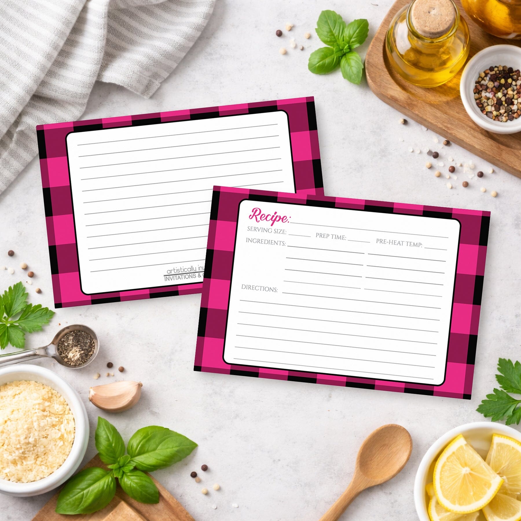 Two Pink and Black Buffalo Plaid Recipe Cards on a kitchen counter with ingredients.