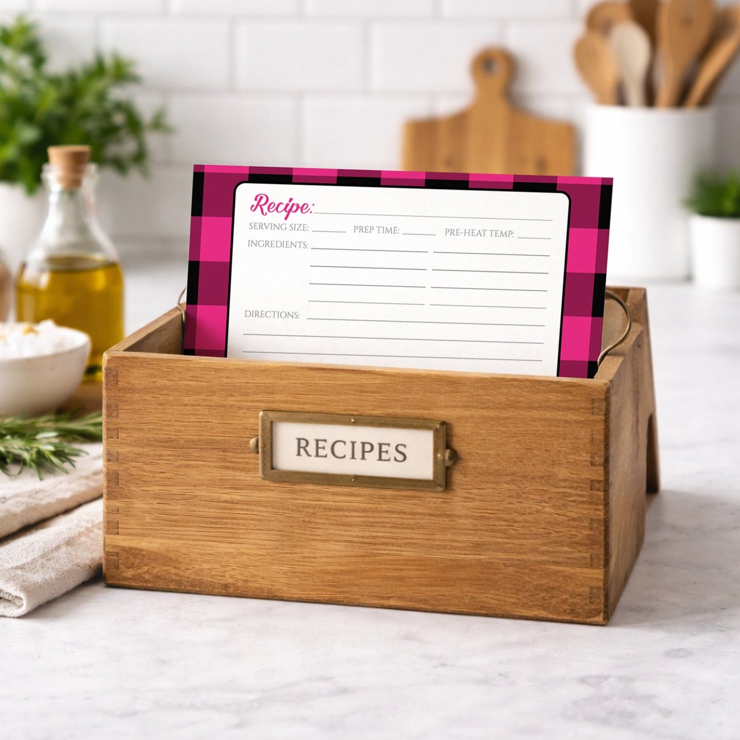Wooden recipe box with a Pink and Black Buffalo Plaid Recipe Card on a kitchen counter.