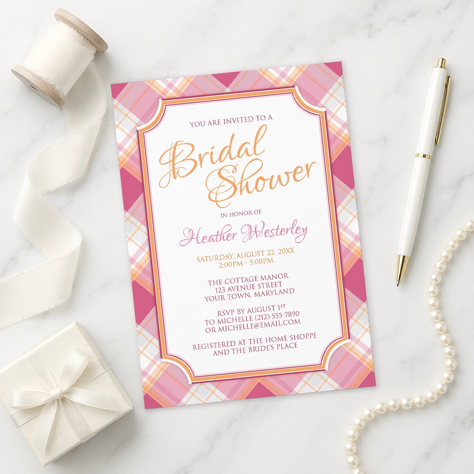 Pink and Orange Plaid Bridal Shower Invitation shown on a marble surface with a white gift box, pen, ribbon, and pearls.