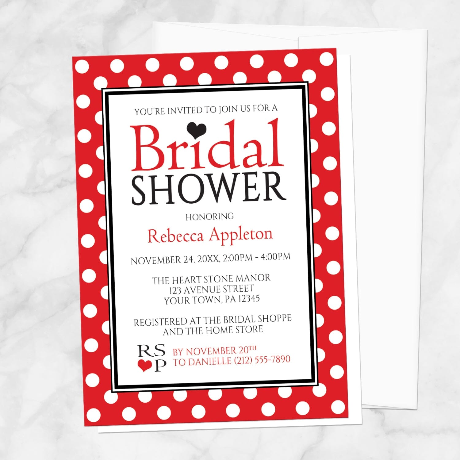 Polka Dot Red Black and White Bridal Shower Invitation shown on a marble surface with a white envelope.