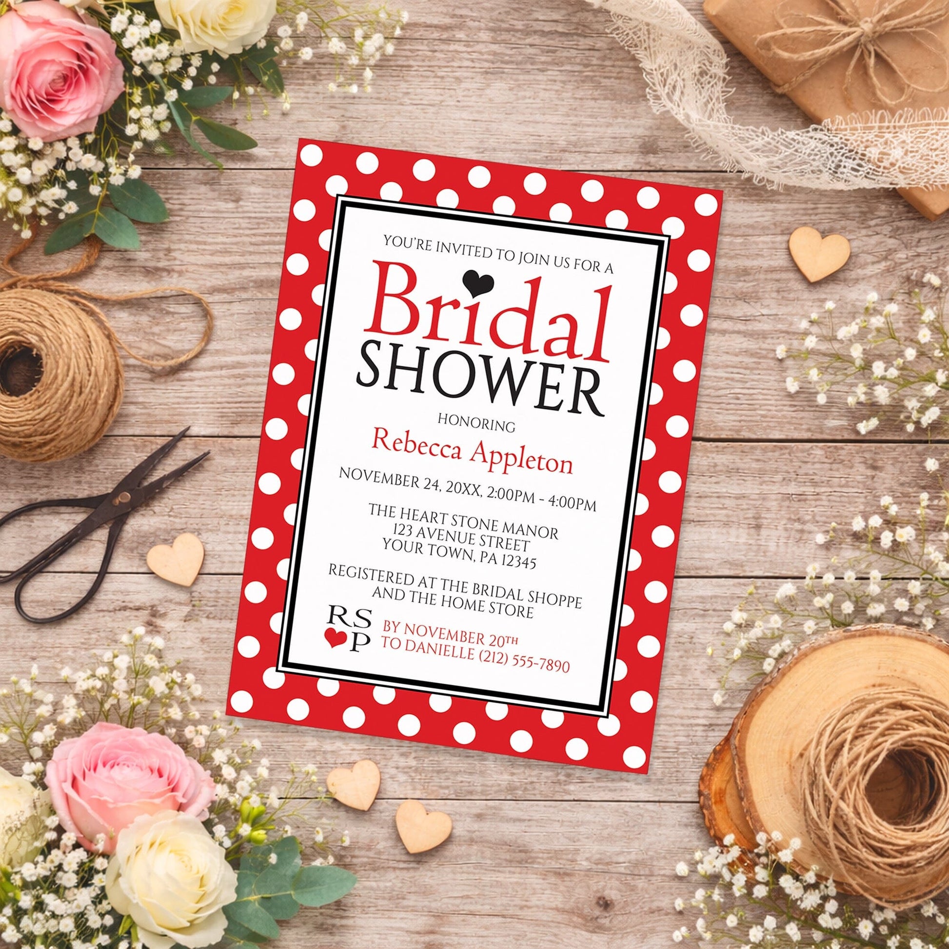 Polka Dot Red Black and White Bridal Shower Invitation shown on a country-style wooden surface with spring and summer flowers, small wood hearts, lace ribbon, and twine.