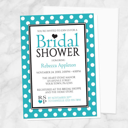 Polka Dot Turquoise Black and White Bridal Shower Invitation shown on a marble surface with a white envelope.