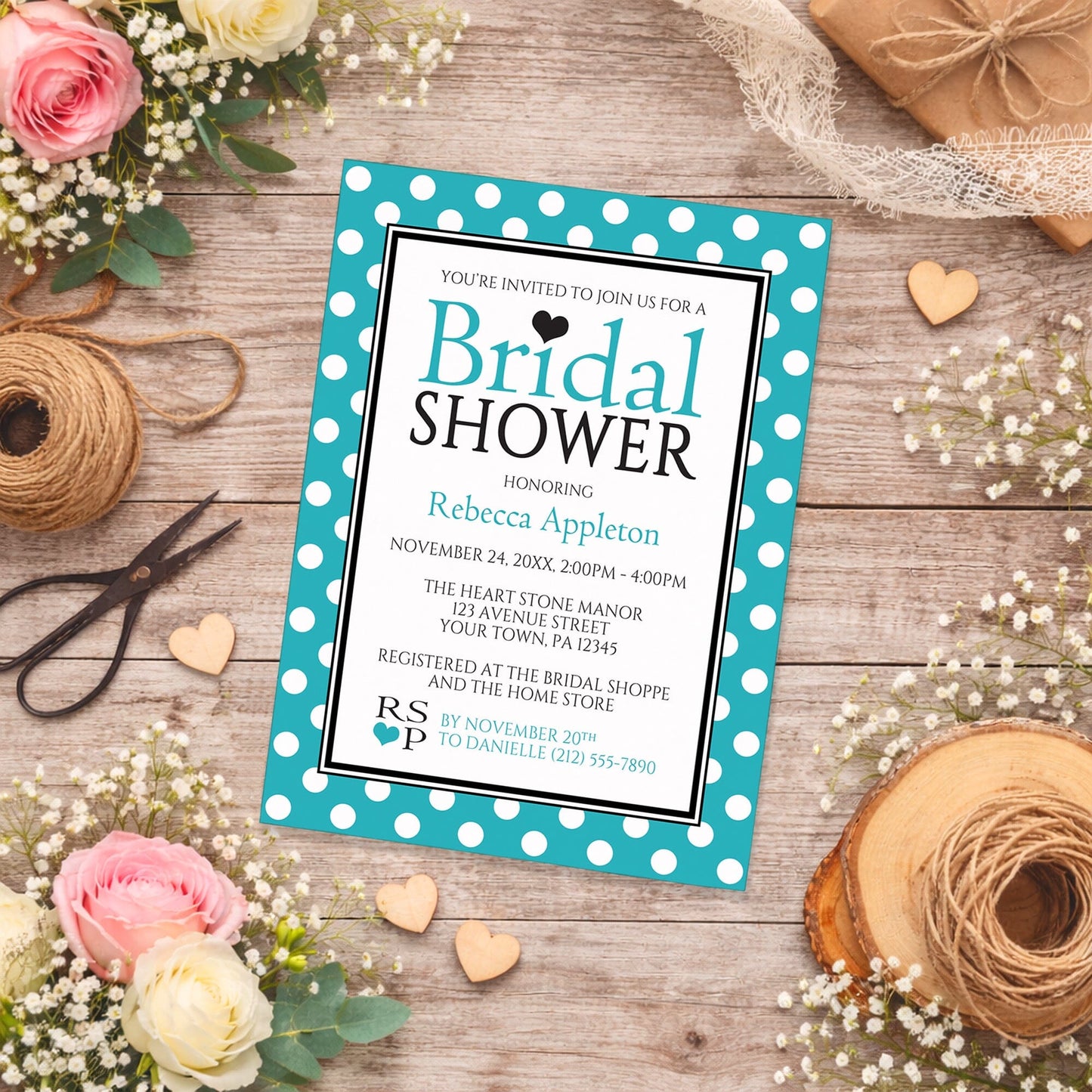 Polka Dot Turquoise Black and White Bridal Shower Invitation shown on a rustic wooden surface with spring and summer flowers, small wood hearts, and twine.