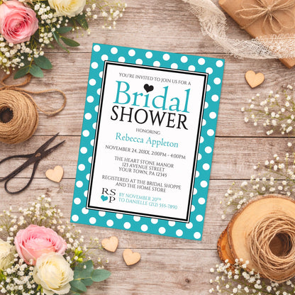 Polka Dot Turquoise Black and White Bridal Shower Invitation shown on a rustic wooden surface with spring and summer flowers, small wood hearts, and twine.