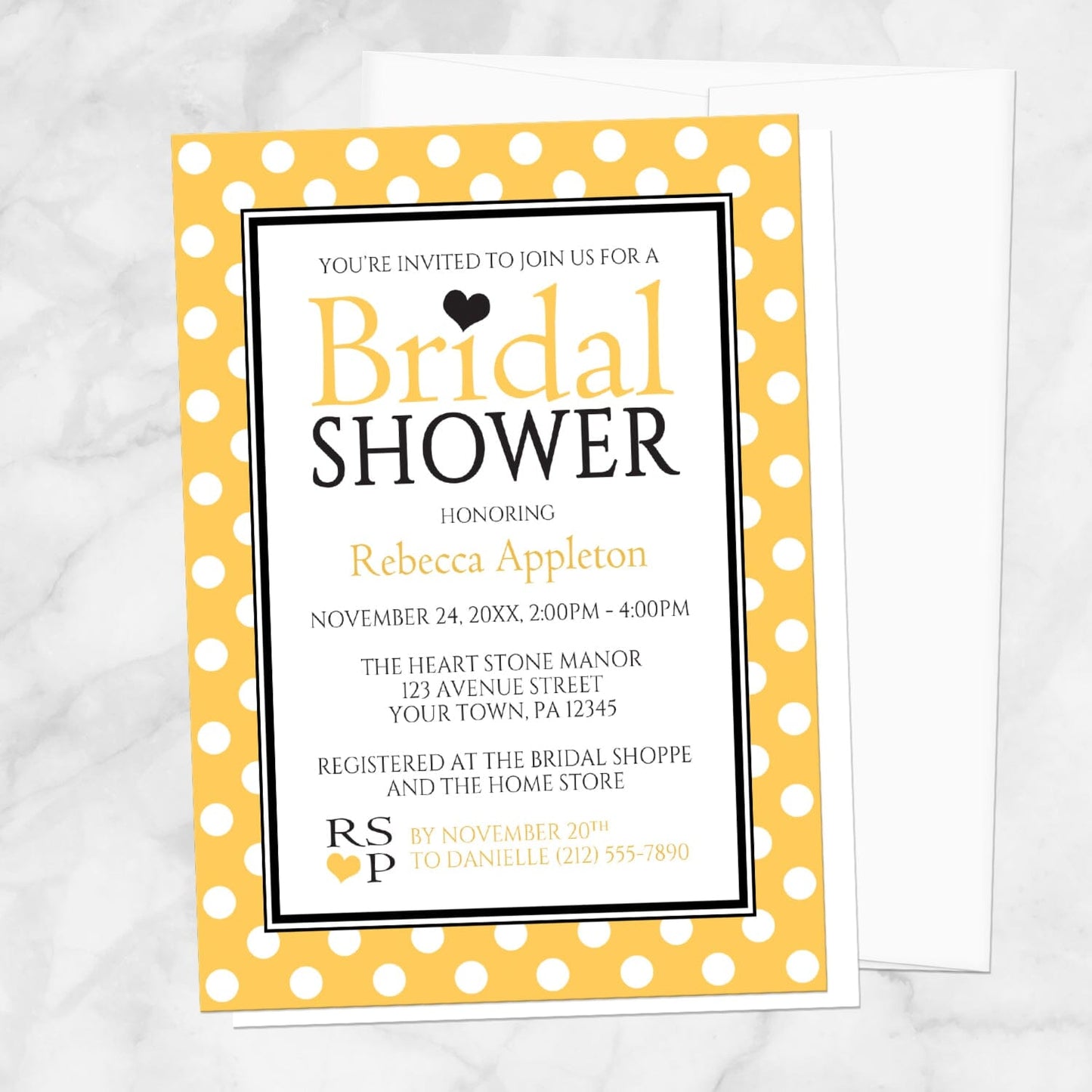 Polka Dot Yellow Black and White Bridal Shower Invitation shown on a marble surface with a white envelope.