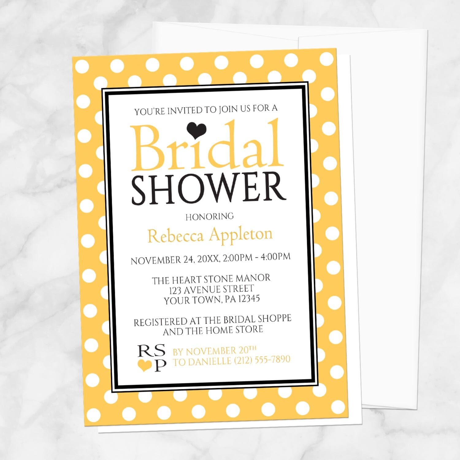 Polka Dot Yellow Black and White Bridal Shower Invitation shown on a marble surface with a white envelope.