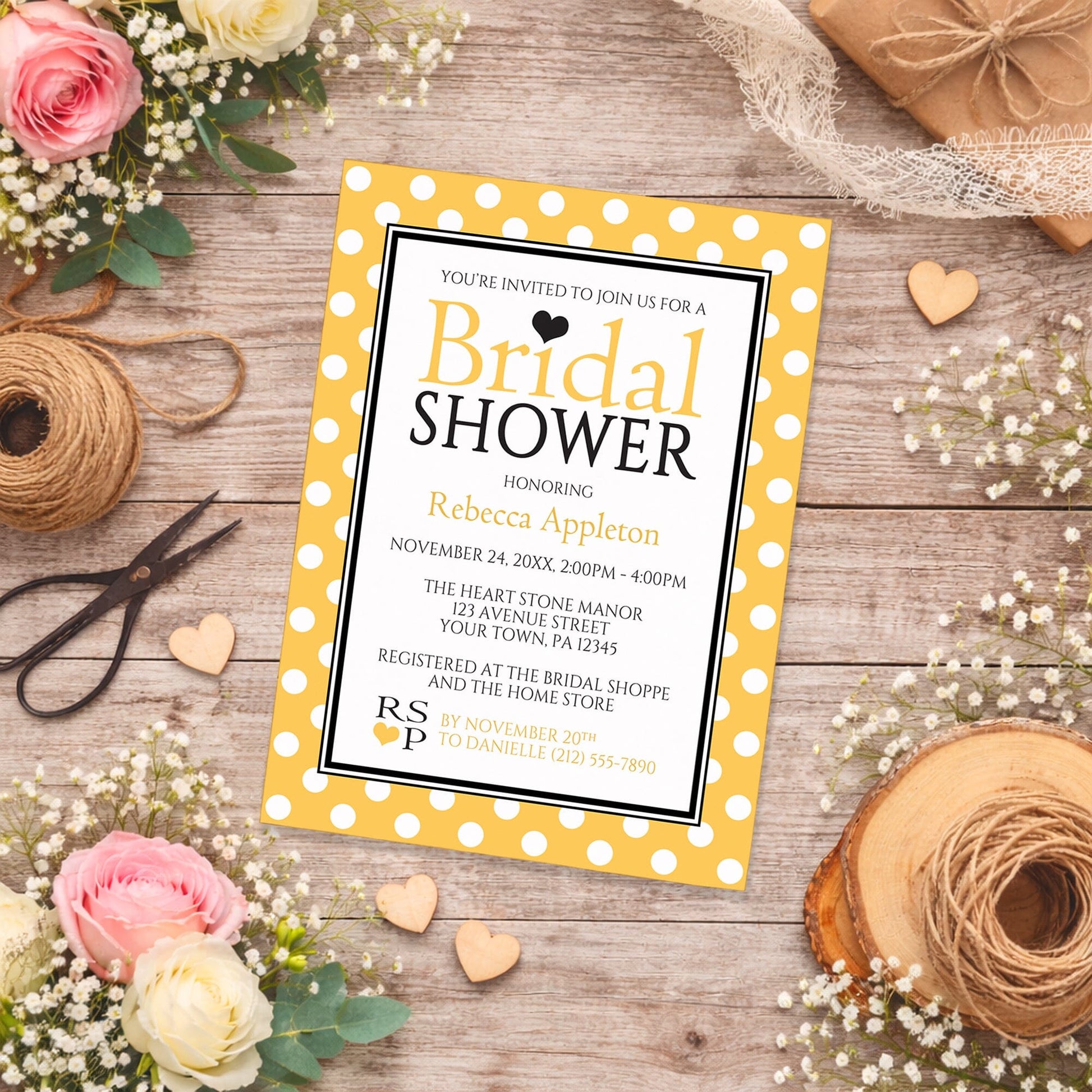 Polka Dot Yellow Black and White Bridal Shower Invitation shown on a country-style surface with spring and summer flowers, small wood hearts, lace ribbon, and twine.