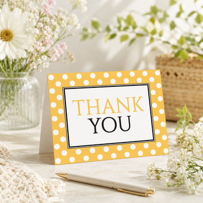 Polka Dot Yellow Black and White Thank You Card shown on a tabletop with a vase, spring and summer flowers, and a pen.
