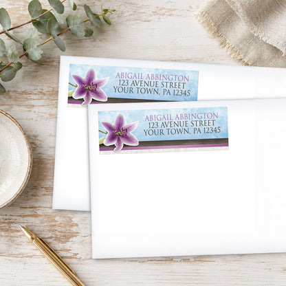 Pretty Floral Wood Purple Lily Address Labels on white envelopes, placed on a wooden surface with eucalyptus leaves and a pen.