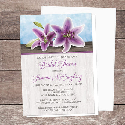 Bridal shower invitation with purple lilies  displayed with a white envelope on a wooden surface