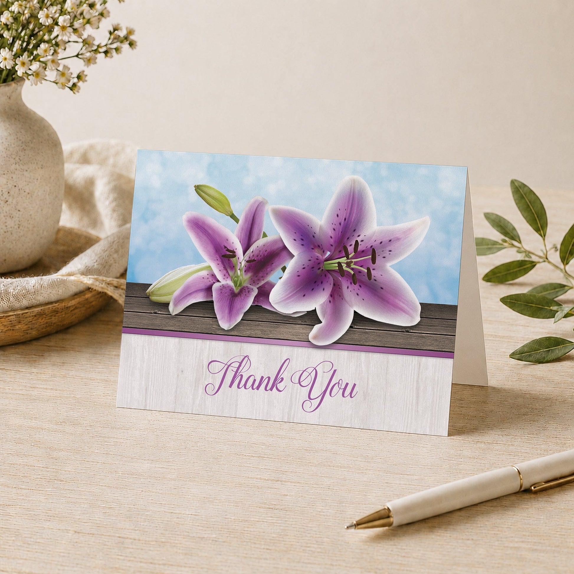 Pretty Floral Wood Purple Lily Thank You Card shown on a tabletop with a vase, plants, and a pen.