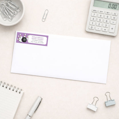 Purple Bowling Return Address Label shown on a white envelope with everyday office supplies