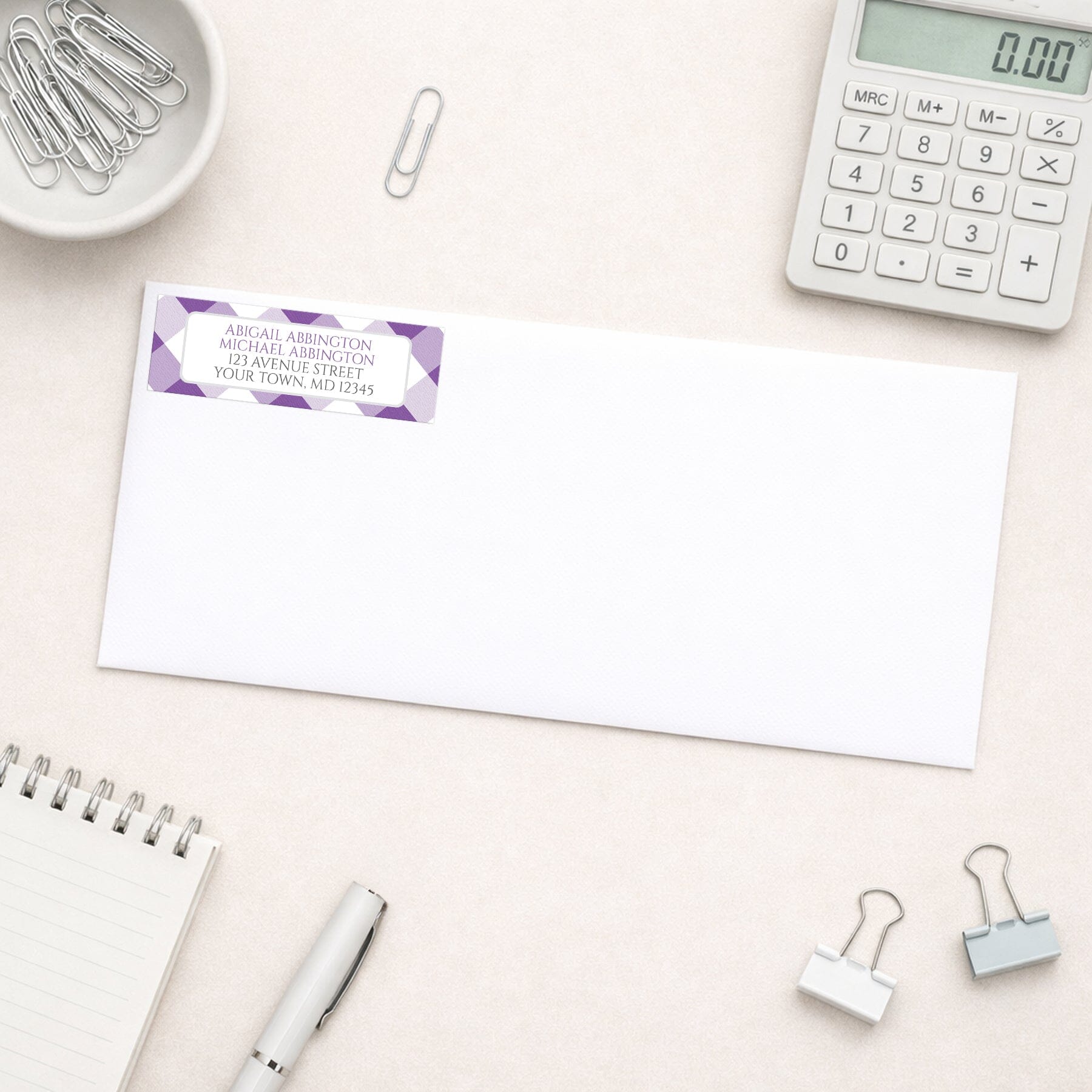 Purple Gingham Address Label shown on a white envelope with everyday office supplies