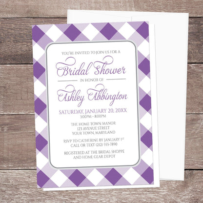 Bridal shower invitation with purple and white gingham check border, displayed with a white envelope on a wooden surface