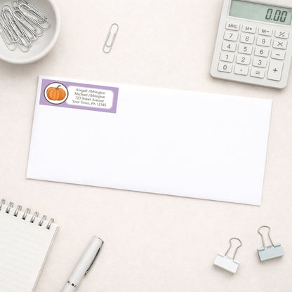 Purple Pumpkin Address Label shown on a white envelope with everyday office supplies