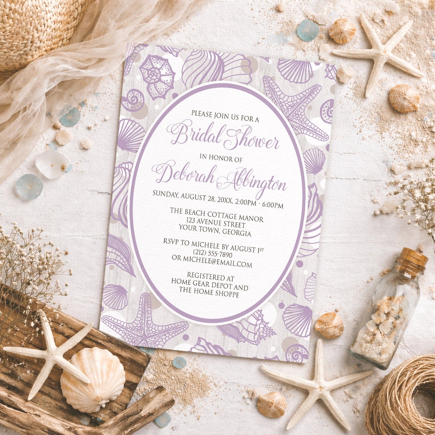 Purple Seashell Whitewashed Wood Beach Bridal Shower Invitation shown on a rough beachy surface with sand and coastal decor.