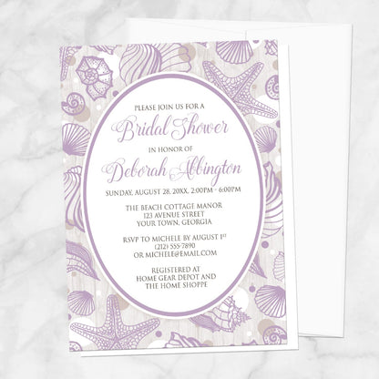 Purple Seashell Whitewashed Wood Beach Bridal Shower Invitation shown on a marble surface with a white envelope.