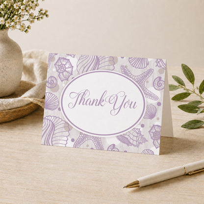 Purple Seashell Whitewashed Wood Beach Thank You Card shown on a desk with a vase, plants, and a pen.