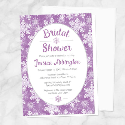 Purple Snowflake Bridal Shower Invitation shown on a marble surface with a white envelope.