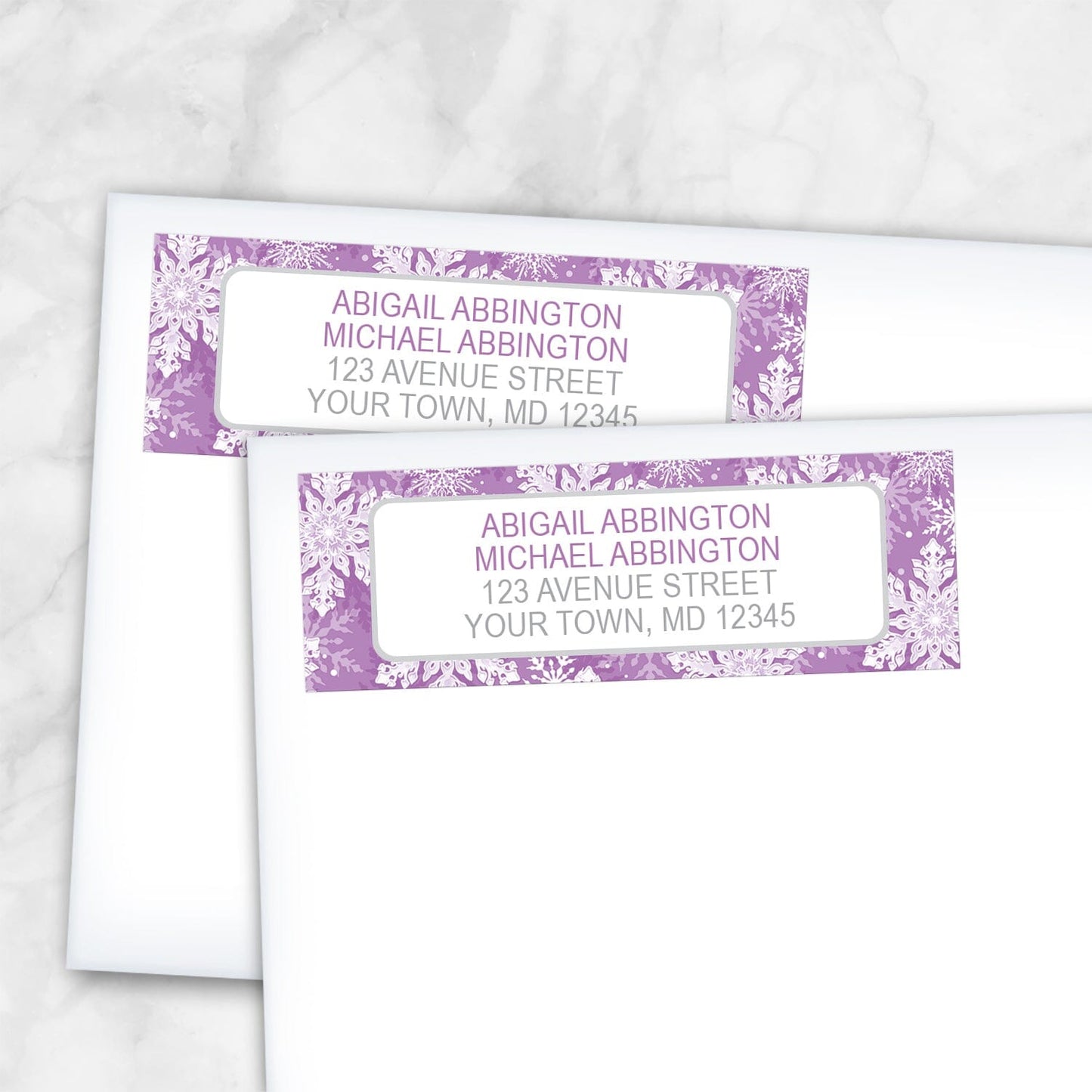 2 Purple Snowflake Winter Return Address Labels shown on white envelopes on a marble surface