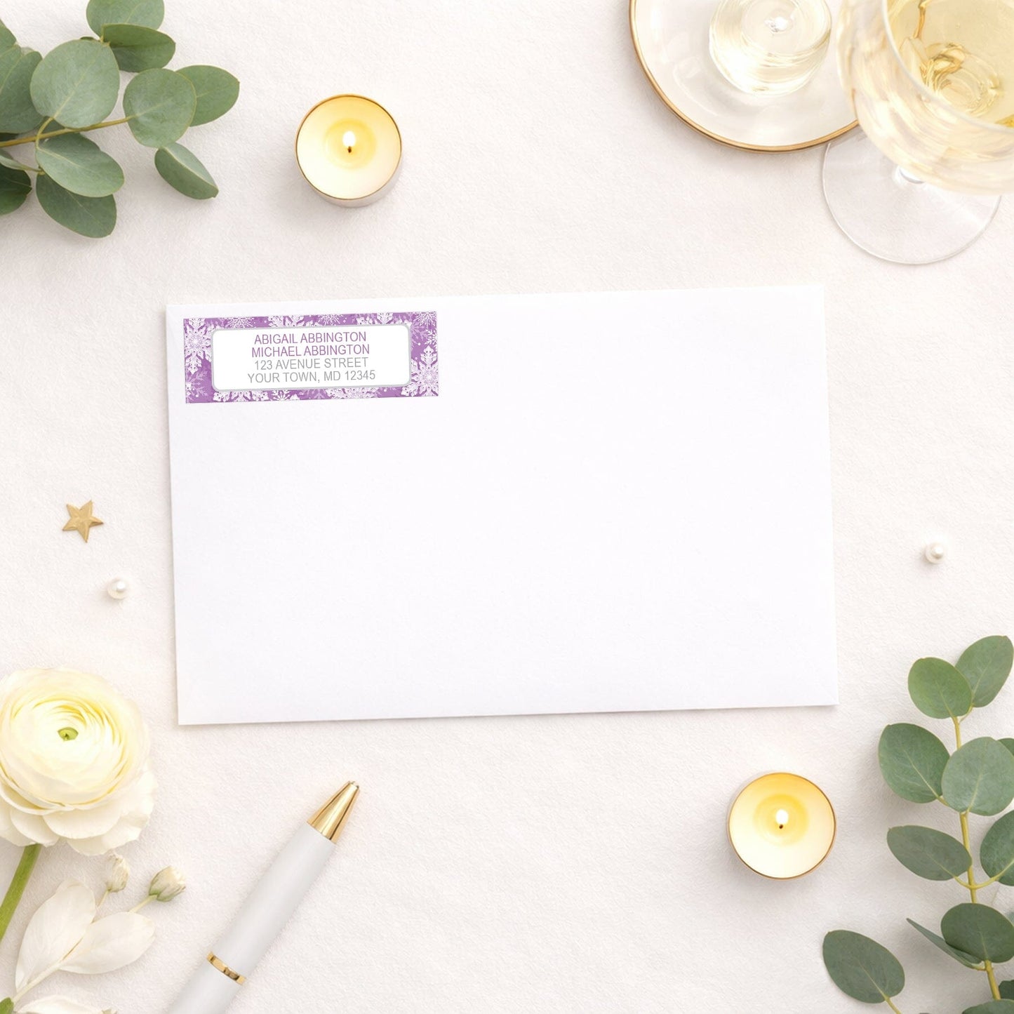 Purple Snowflake Winter Return Address Label shown on a white envelope with wedding and shower supplies