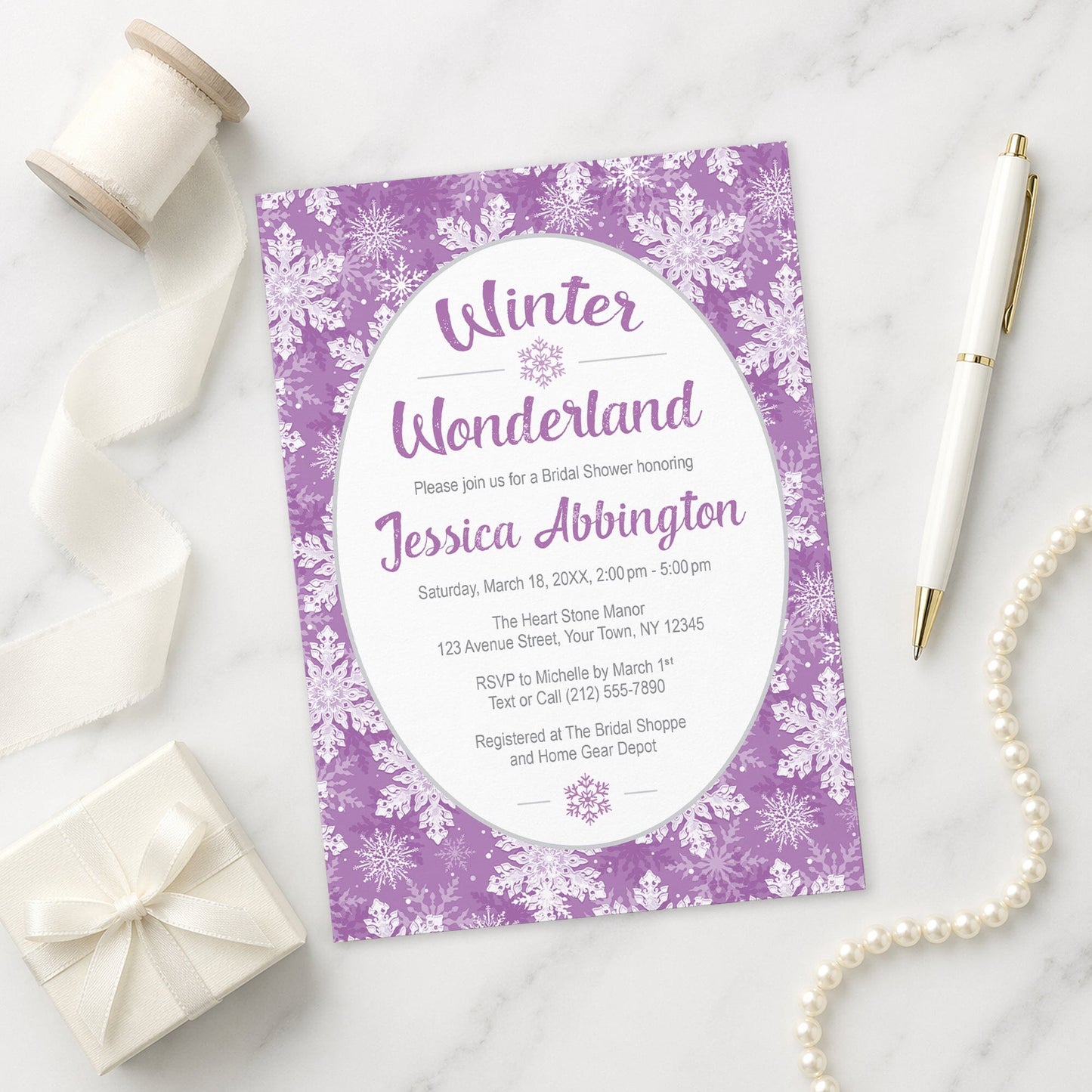 Purple Snowflake Winter Wonderland Bridal Shower Invitation shown on a marble surface with a white gift box, pen, ribbon, and pearls.