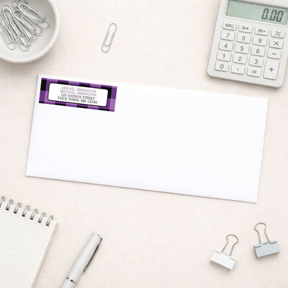 Purple and Black Buffalo Plaid Address Label shown on a white envelope with everyday office supplies