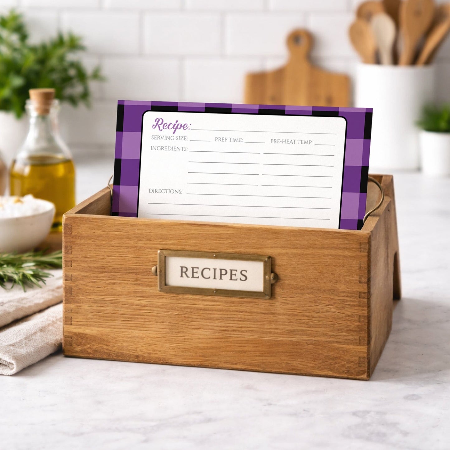 Wooden recipe box with a Purple and Black Buffalo Plaid Recipe Card on a kitchen counter.