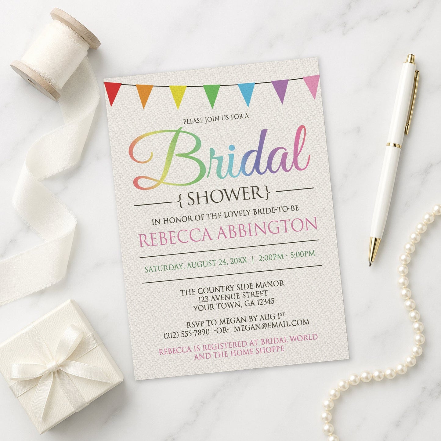 Rainbow Bunting Flags Rustic Bridal Shower Invitation shown on a marble surface with a white gift box, pen, ribbon, and pearls.