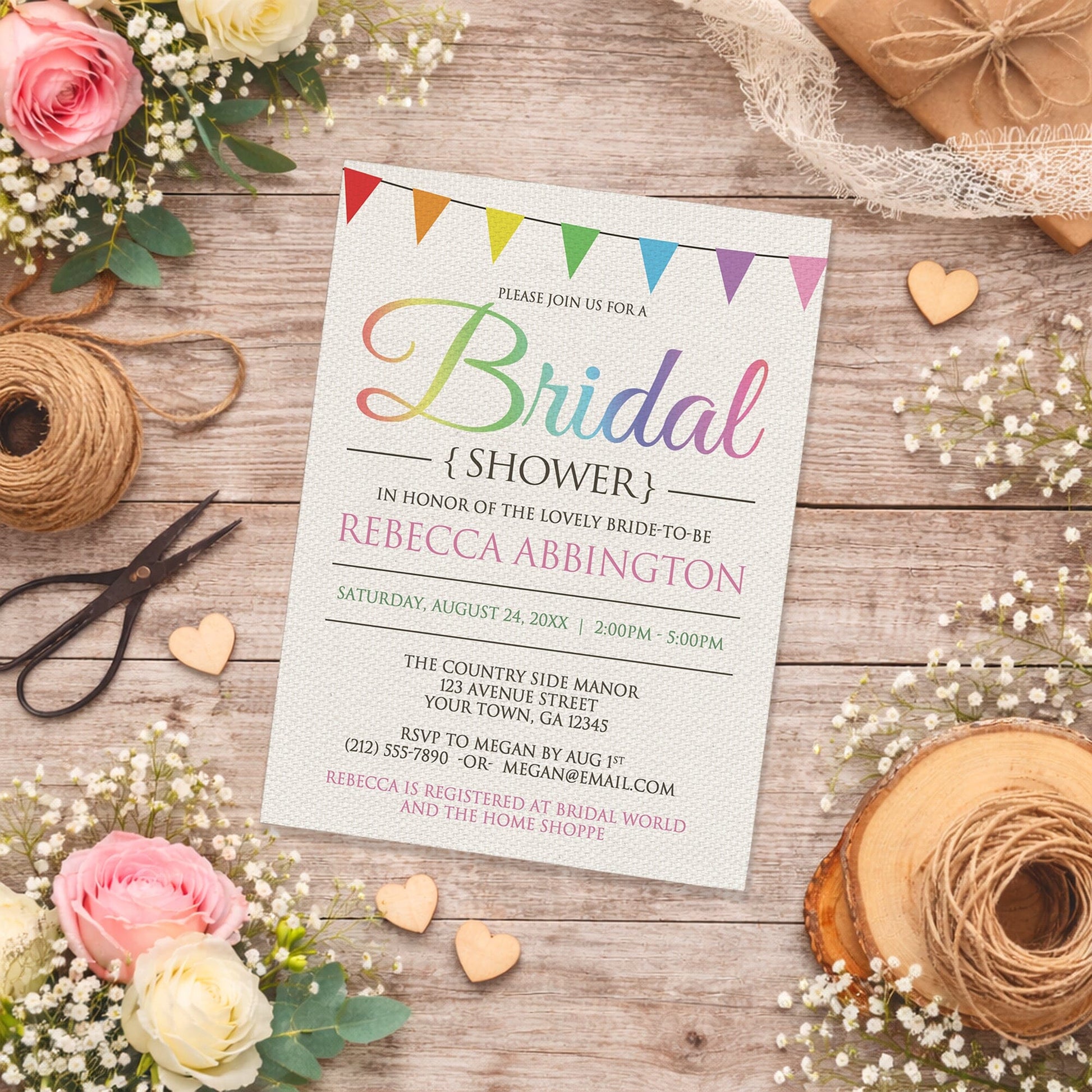 Rainbow Bunting Flags Rustic Bridal Shower Invitation shown on a country-inspired wooden surface with spring and summer flowers, small wood hearts, lace ribbon, and twine.