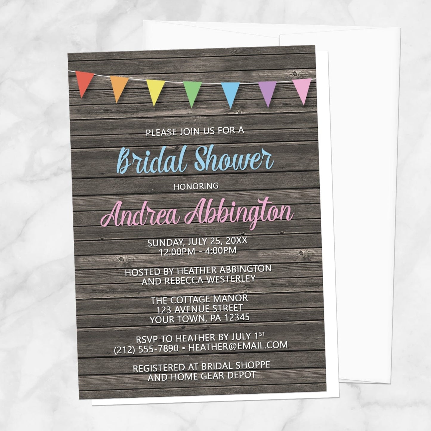 Rainbow Bunting Flags Rustic Wood Bridal Shower Invitation shown on a marble surface with a white envelope.