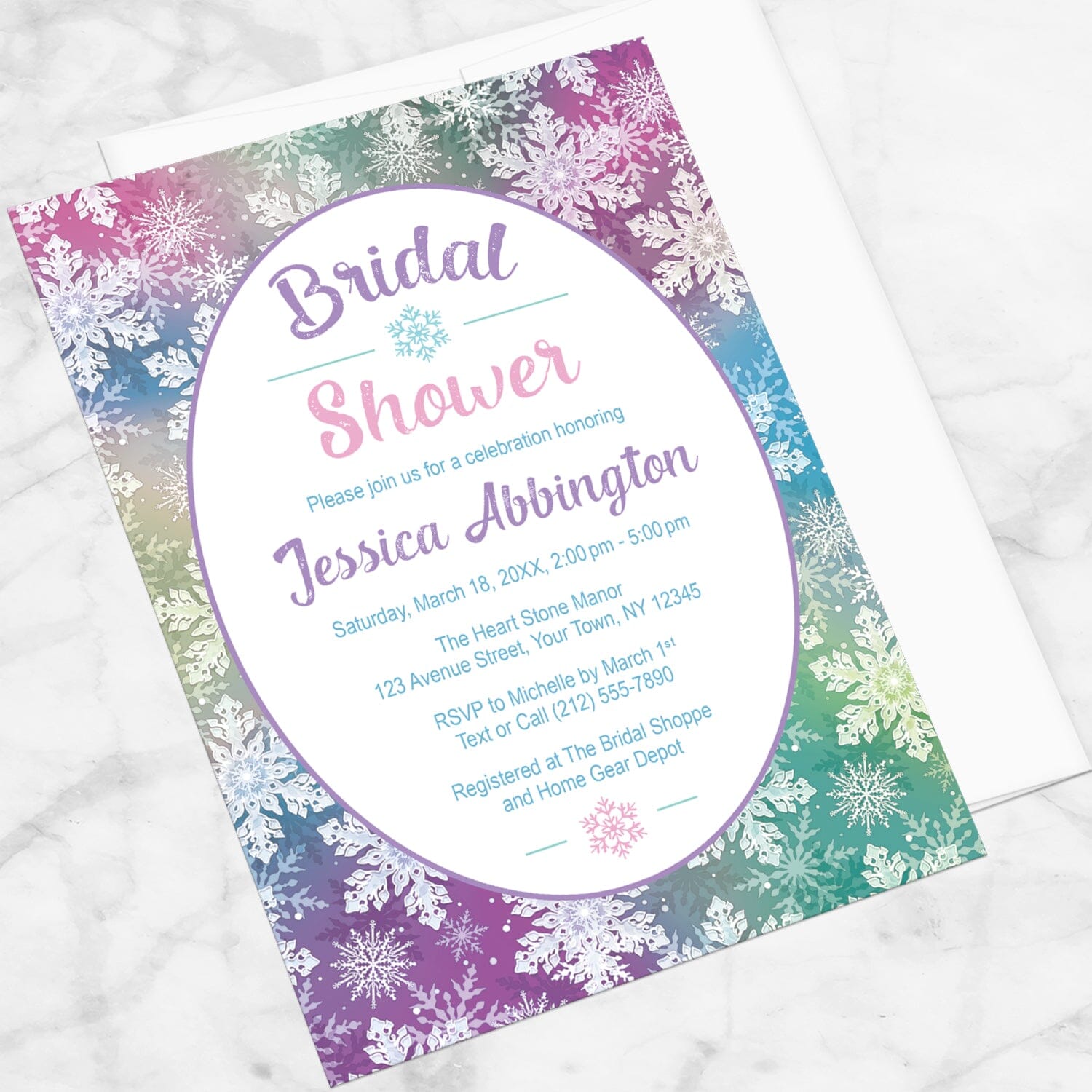 Rainbow Snowflake Bridal Shower Invitation shown at an angle on a marble surface with a white envelope.