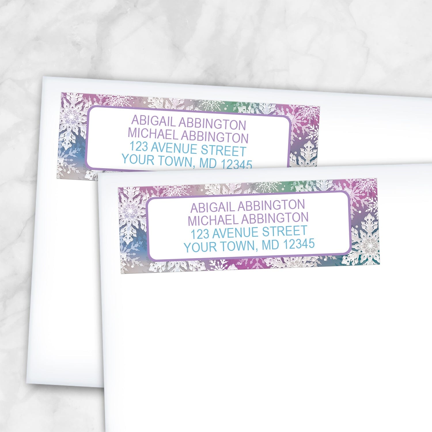 2 Rainbow Snowflake Winter Return Address Labels shown on white envelopes on a marble surface