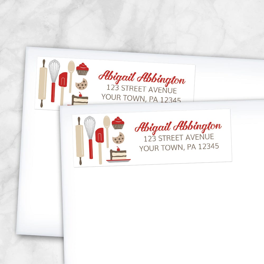 Red Baking Address Labels at Artistically Invited. Image shows 2 labels on envelopes. High-quality address labels designed with cute kitchen baking tools and baked treats in red, brown, gray, and beige on the left side over a white background. Your personalized return address is custom printed in red and brown to the right of the red baking tools and baked goods design. These premium return address labels are great for bakers, pastry chefs, or anyone who loves baking.