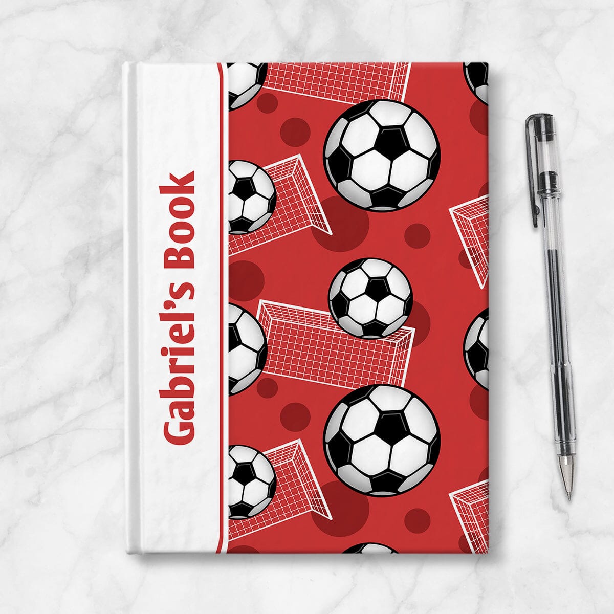 Personalized Red Soccer Journal at Artistically Invited. Image shows the book on a countertop next to a pen.