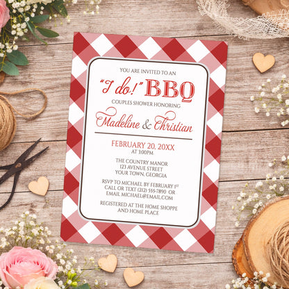 Red Gingham I Do BBQ Couples Shower Invitation shown on a wooden surface with spring and summer flowers, small wood hearts, lace, and twine.