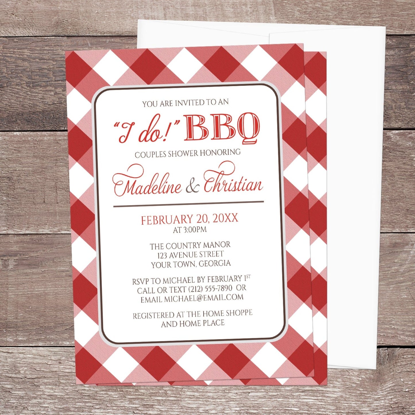 Red Gingham I Do BBQ Couples Shower Invitation shown on a brown wood surface with a white envelope.