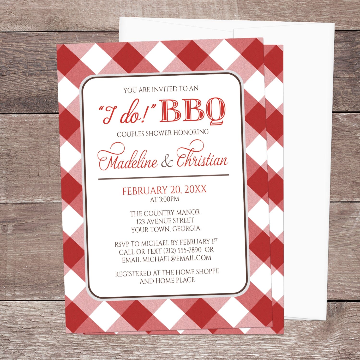 Red Gingham I Do BBQ Couples Shower Invitation shown on a brown wood surface with a white envelope.