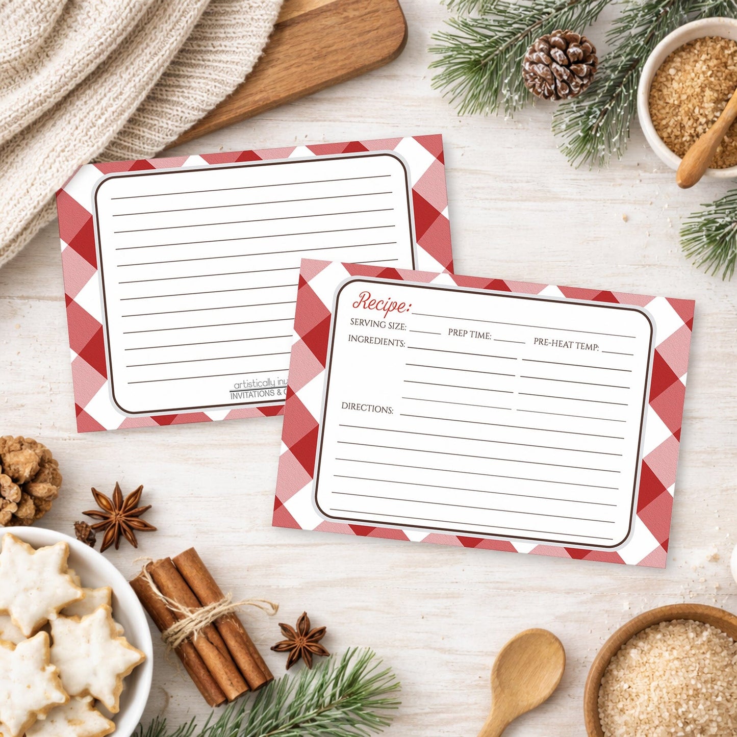 Two Red Gingham Recipe Cards on a wooden surface with winter and holiday decorations.