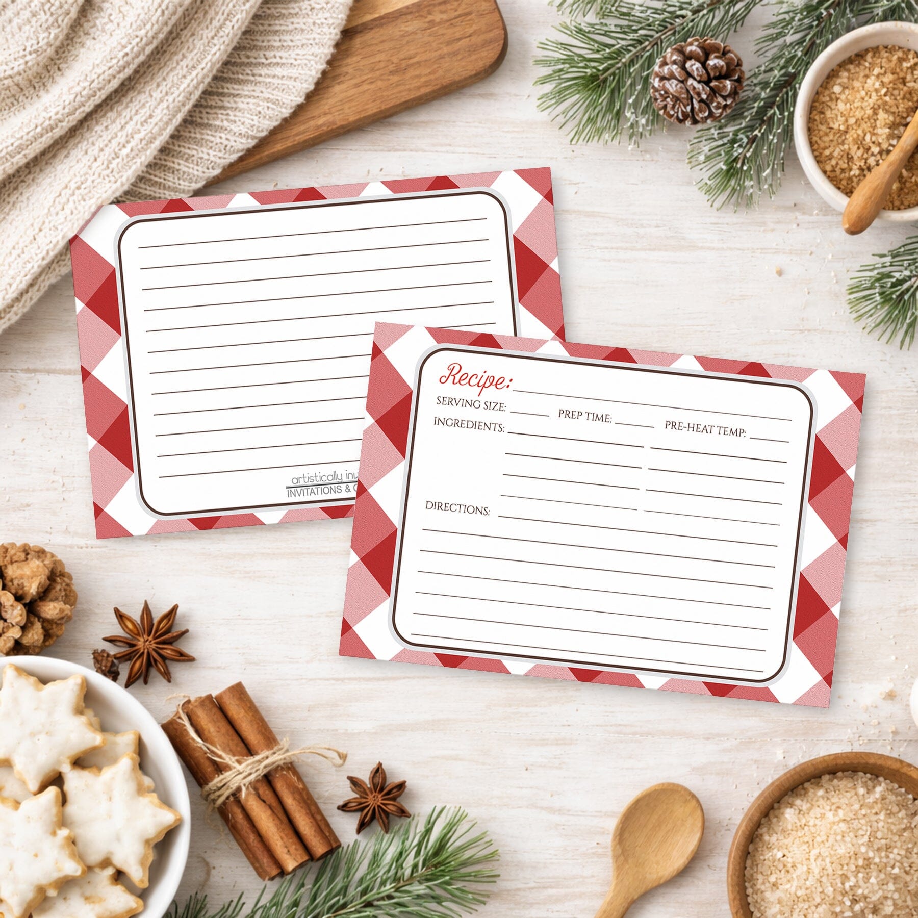 Two Red Gingham Recipe Cards on a wooden surface with winter and holiday decorations.