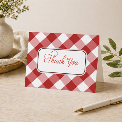 Red Gingham Thank You Card shown on a desk with a vase, plants, and a pen.